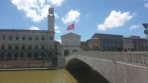 The red flag of Pisa waving in the wind on the bridge "Ponte di Mezzo", Arno Stock Footage 133915180