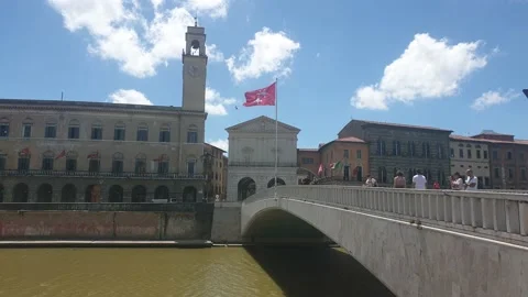 The red flag of Pisa waving in the wind on the bridge "Ponte di Mezzo", Arno Stock Footage 133915196