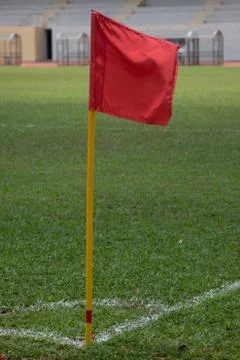 Red flag pole at corner kick marking of soccer field Stock Photos