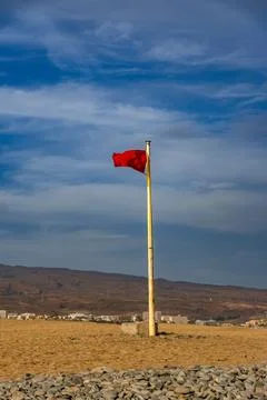 A red flag is on a pole in a field Stock Photos