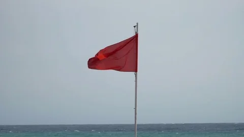 Red flag with sea at the background. 4x slow motion Stock Footage 80069617