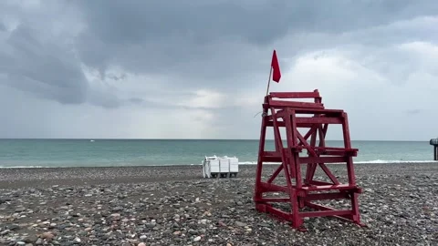 Red flag sways in wind. Rescue tower. Danger signal Stock Footage 250636533