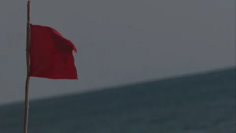 Red Flag Waving in Slow Motion over Beach in Cozumel, Mexico Stock Footage 82879568