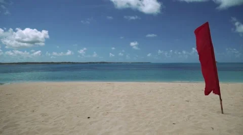 Red flag on white sand beach on tropical island Video stock 67412806