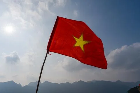 Red flag with yellow star waves in mountain breeze Stock Photos