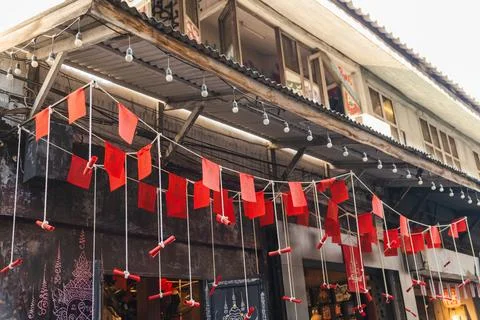 Red Flags and String Lights Decorating a Weathered Bangkok Shophouse Stock Photos