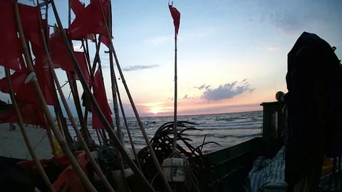 Red flags on the fishing boat while sunset Vidéo 121682968