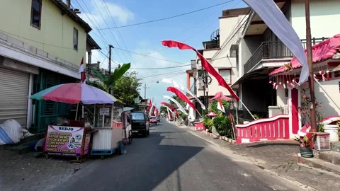 Red flags flutter above a quiet village street Stock Footage 345156953