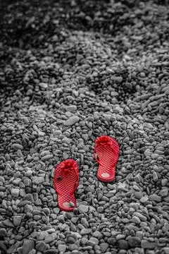 Red flip flops on pebbled beach Stock Photos