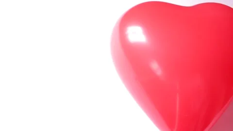 Red flying balloon in heart shape on a string moves from top to the center of Stock Footage 231309225