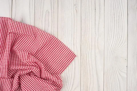 Red folded tablecloth over bleached wooden table. Stock Photos