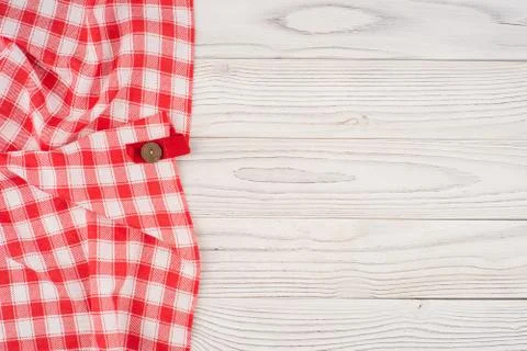 Red folded tablecloth over bleached wooden table. Stock Photos