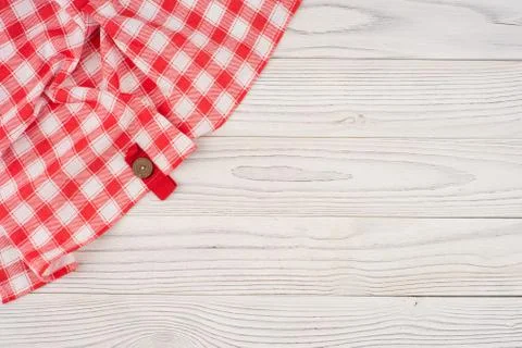 Red folded tablecloth over bleached wooden table. Stock Photos