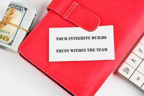 A red folder with a card stating integrity builds trust, placed next to a sta Stock Photos