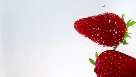 Red fresh fruit strawberries falling into water with splash Stock Footage 77346899