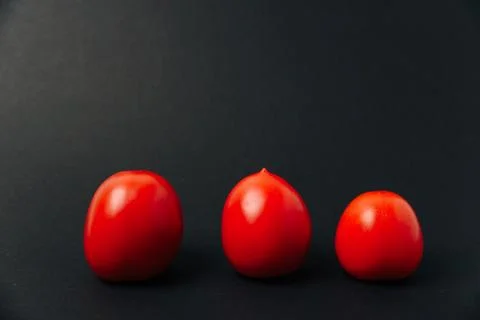 Red fresh tomatoes on a black background Stock Photos