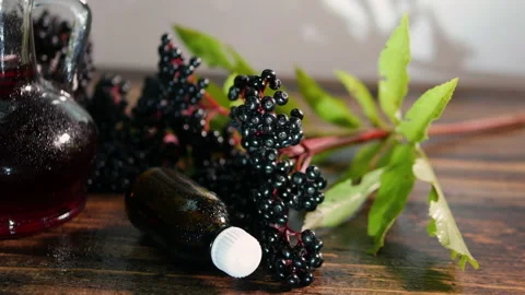 Red freshly squeezed juice in a bottle, elderberry herb tincture, black berry Stock Footage