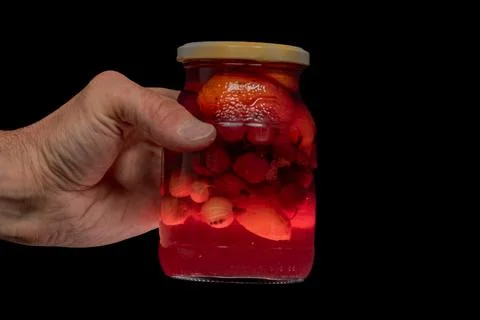 Red fruit mix compote in hand with black backtound isolated Stock Photos