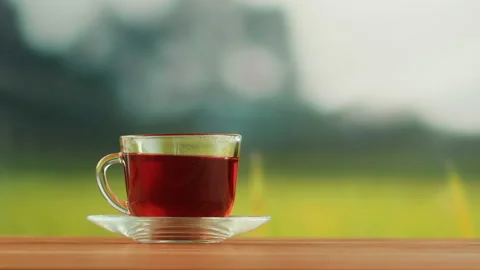 Red fruit tea in glass cup on a wooden table. Hibiscus tea ceremony process Stock Footage 191094892