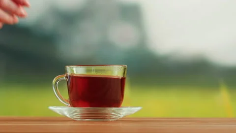 Red fruit tea in glass cup on a wooden table. Hibiscus tea ceremony process Stock Footage 191094899