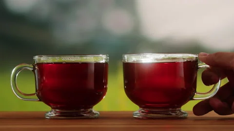 Red fruit tea in glass cups on a wooden table. Hibiscus tea ceremony process Stock Footage 190886849