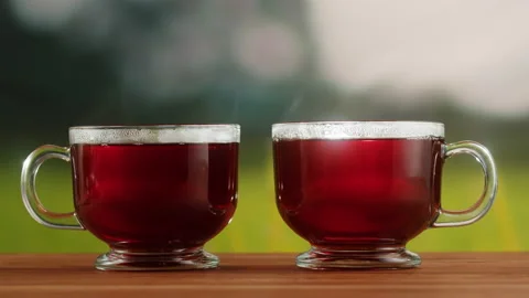Red fruit tea in glass cups on a wooden table. Hibiscus tea ceremony process Stock Footage 191095096