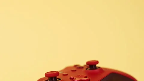 Red gaming controller isolated on light yellow slow panning Stock Footage 241774595