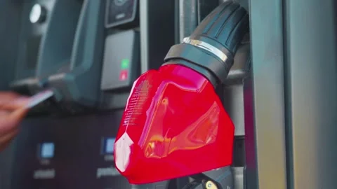 Red gas pump nozzle handle at service station dispenser 库存影片 338023941