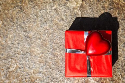 Red gift and heart on stony background 写真素材
