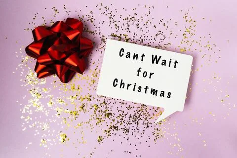 Red Gift Bow with Christmas Message on Purple Background Фото