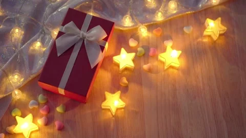 Red gift box and candlelight on a wooden table. Stock Footage 255282836