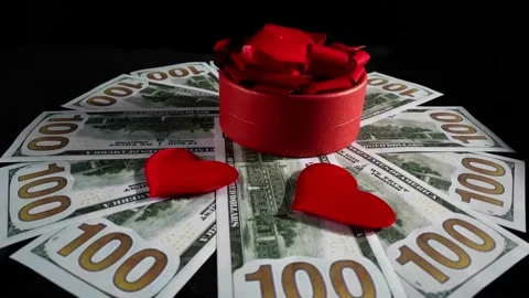 Red gift box and hearts rotating on money background. Stock Footage 232309178
