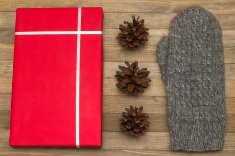 Red gift box and pine cone with mitten Foto stock