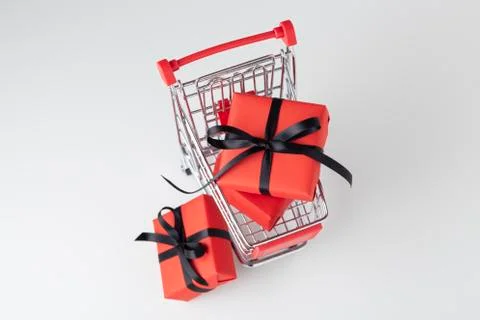 Red gift box with black bow in shopping cart, black friday sale 스톡 사진