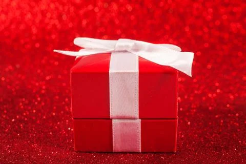 Red gift box on glitter red background Stock Photos