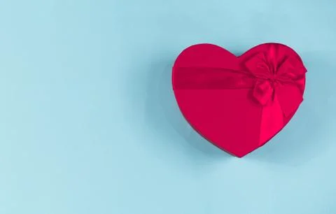 Red gift box heart shape with red ribbon on a blue background, gift concept Stock Photos