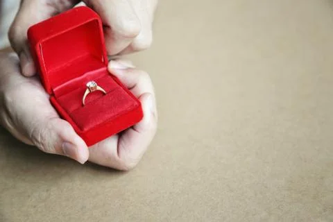 Red gift box opened with diamond ring in mans hands. Stock Photos