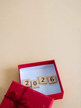 Red gift box opened showcasing wooden numbers symbolizing the year 2026 aga.. Stock Photos