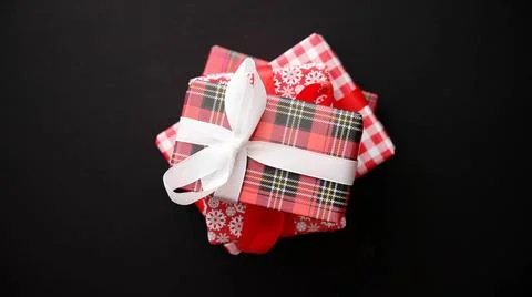 Red gift box with red bow on black table, top view Stack of gifts boxes wr... Stockfoto's