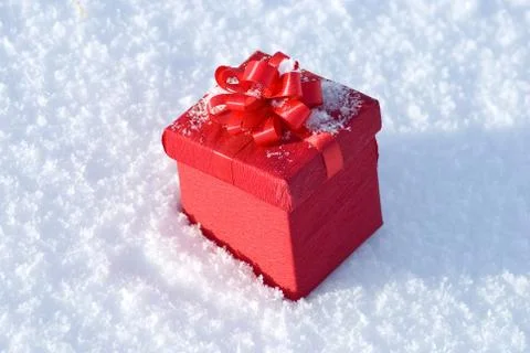 Red gift box on snow Stock Photos