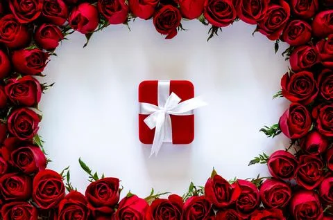 Red gift box on white background with roses frame for anniversary and Valen.. Stock Photos