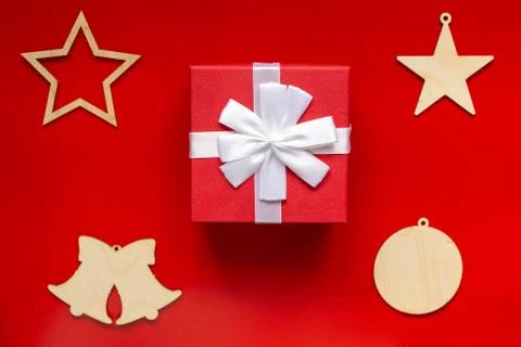 Red gift box with white bow and Christmas wooden decorations in the form of Stock Photos