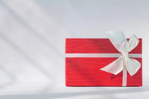 Red gift box with white bow on white background. Holiday greeting card Stock Photos