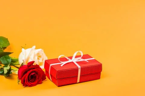 Red gift box with a white ribbon and roses Stock-Fotos
