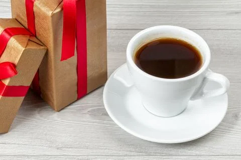Red gift boxes with a cup of coffee on the gray background. Stock Photos