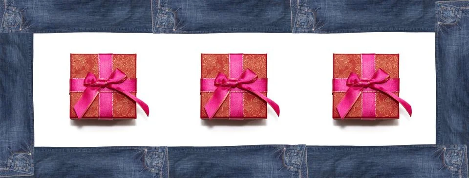 Red gift boxes enclosed within rectangular frame made of dark blue jeans on w Foto stock