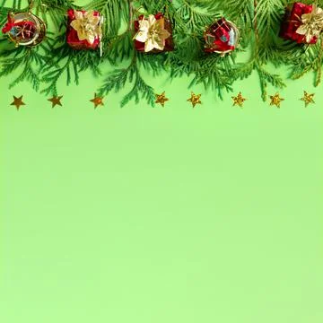 Red gift boxes with gold braid and branches of New Year tree on green paper.  Stock Photos