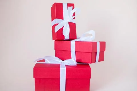 Red gift boxes of various sizes tied with a white satin ribbon Stock Photos