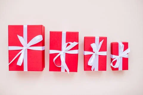 Red gift boxes of various sizes tied with a white satin ribbon Stock Photos