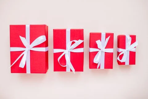 Red gift boxes of various sizes tied with a white satin ribbon Stock Photos